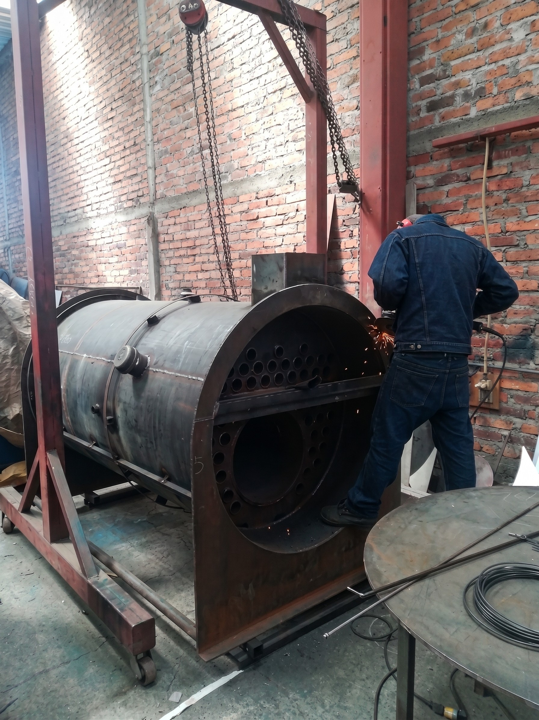 Proceso de soldadura de caldera industrial en taller